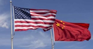 American Chinese windy day flags fly together on flagpole