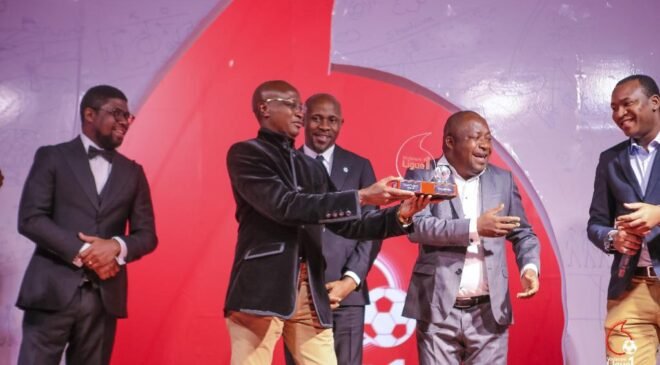 Le directeur marketing de Vodacom Congo Albert Mboyo remet le trophée au directeur général adjoint de la Bracongo. Ph. VL1